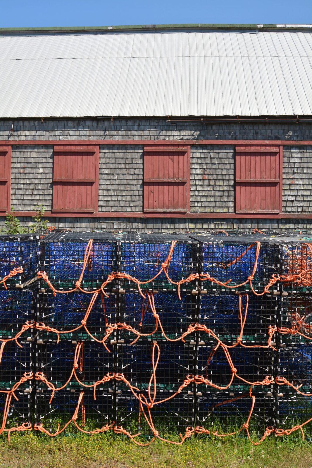 A row of lobster cages in front of a building.