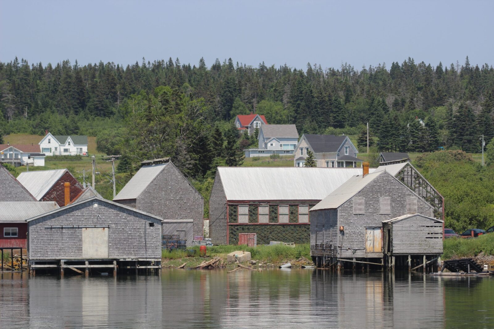 A group of houses on the shore of a body of water.