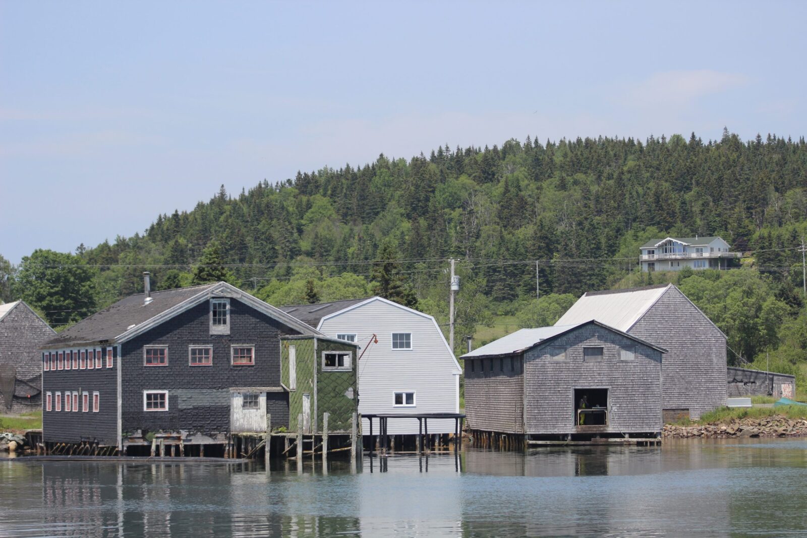 A group of houses on a dock near a body of water.