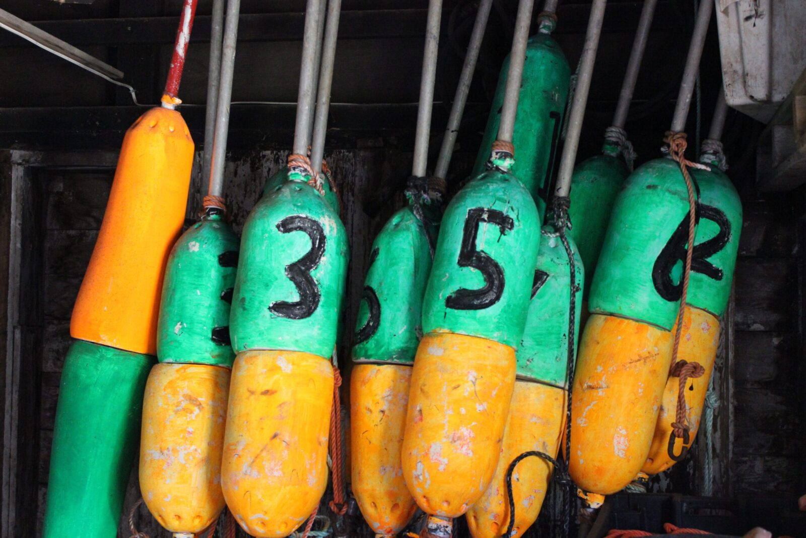 A group of green and yellow buoys with numbers on them.