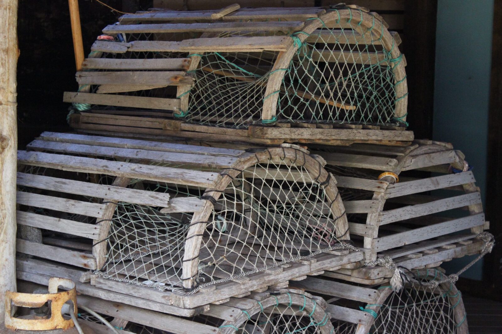A group of lobster cages sitting on a wooden floor.