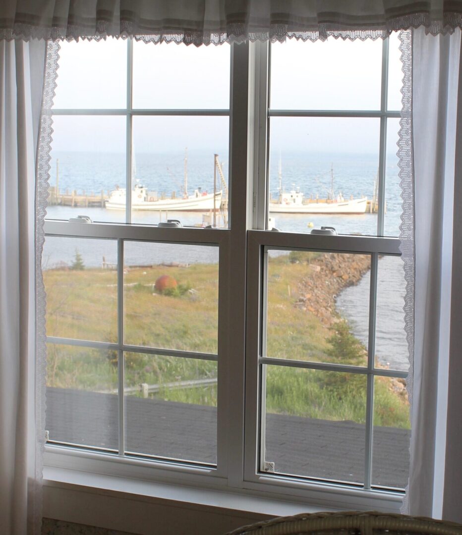 A view of the ocean from a window in a room.