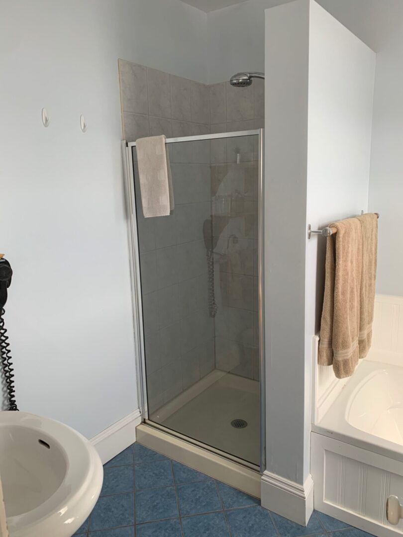 A bathroom with a shower stall, sink and toilet.