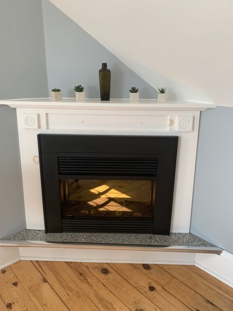 A fireplace in an attic room with a white mantel.