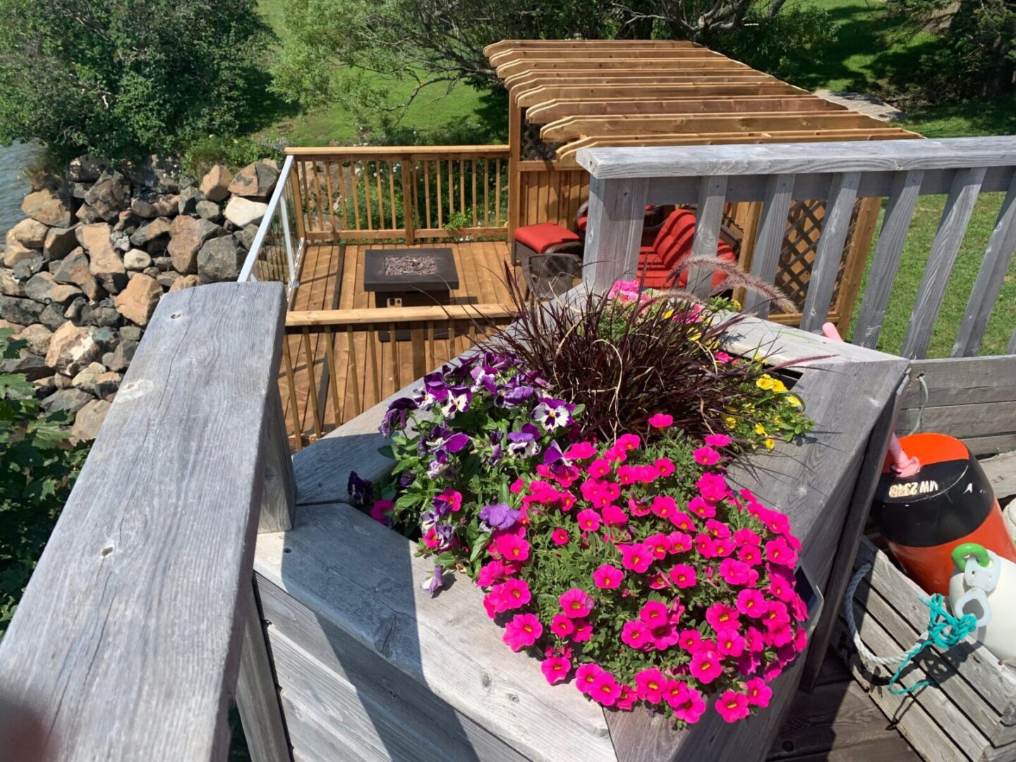 A deck with flower pots on top of it.