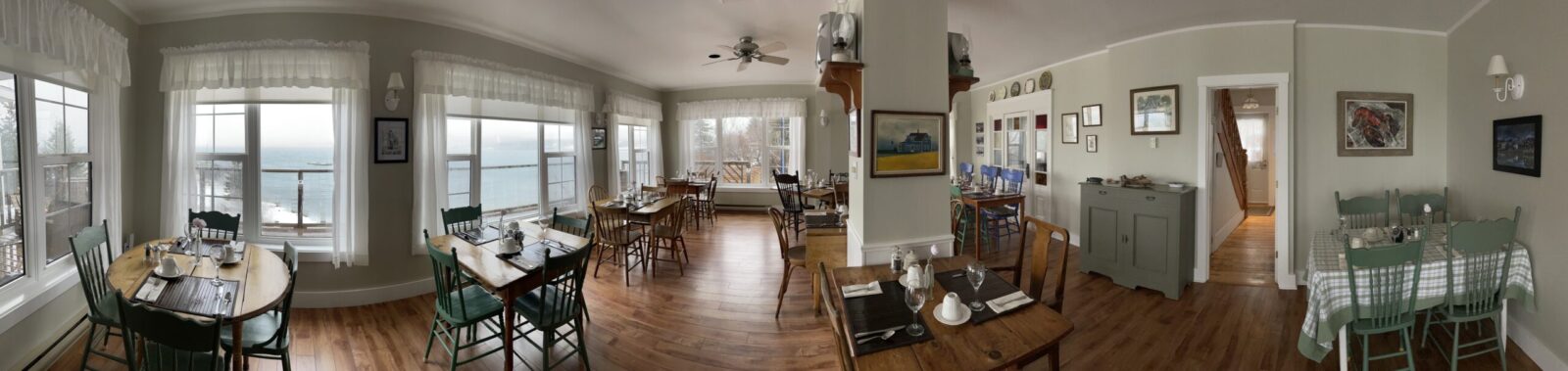 A 360 degree view of a dining room with a view of the ocean.