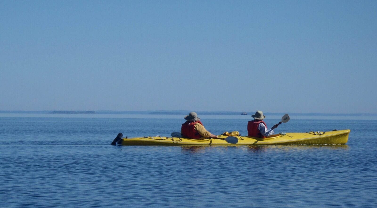 Two people in a yellow kayak on the water.