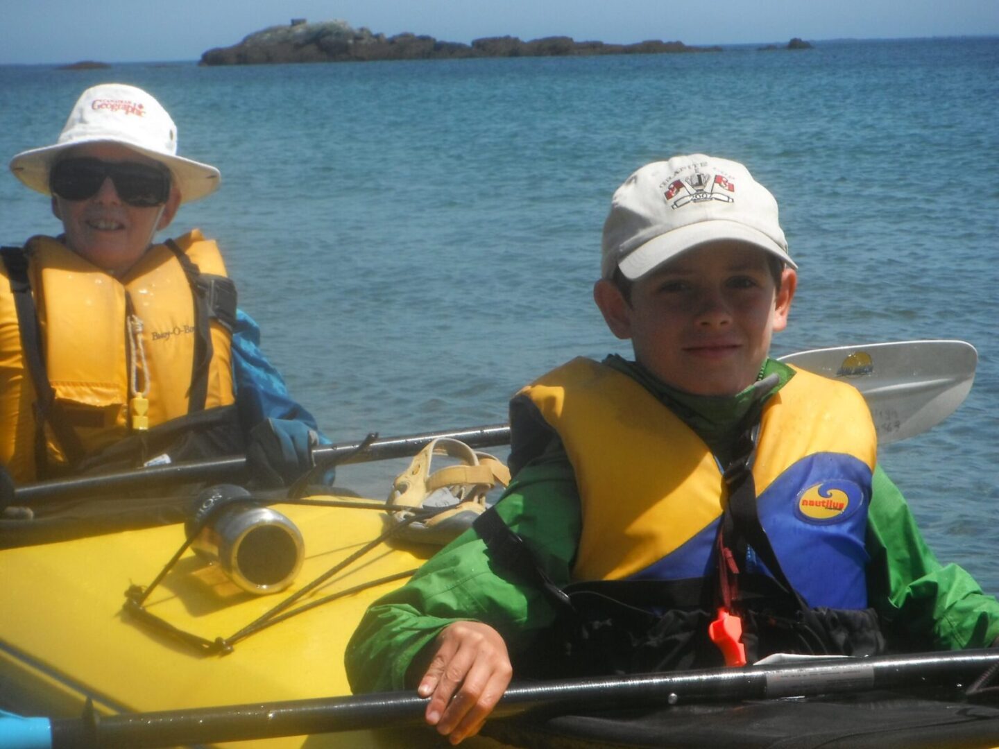 A boy and a girl in a yellow kayak.