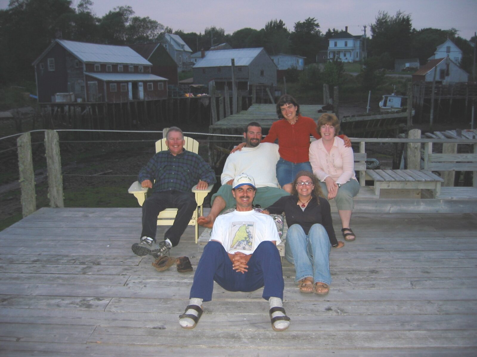 A group of people posing on a wooden deck.