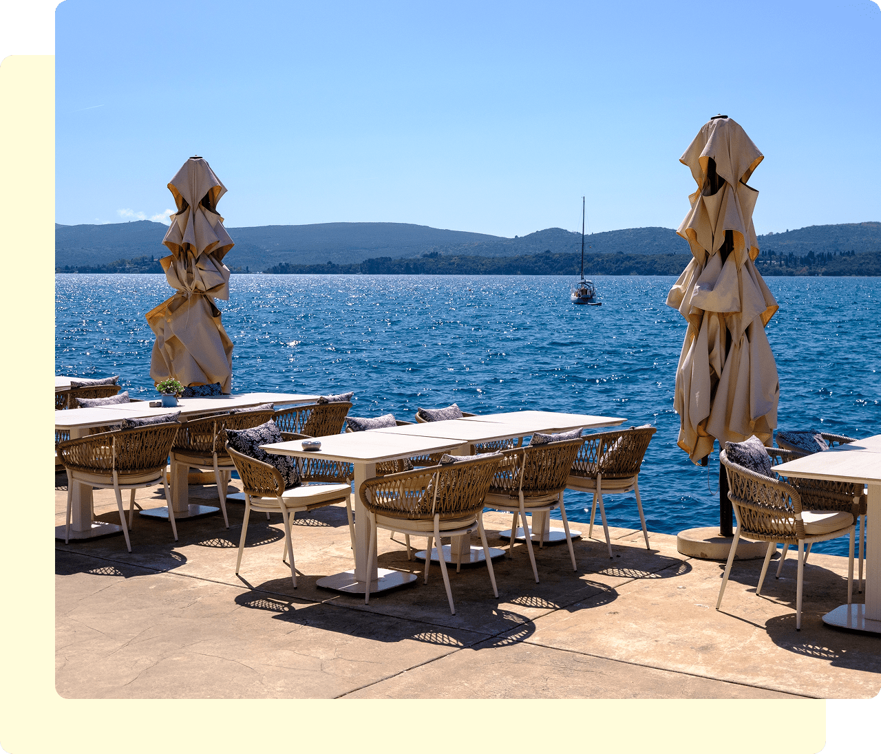 Seaside dining area with closed umbrellas.