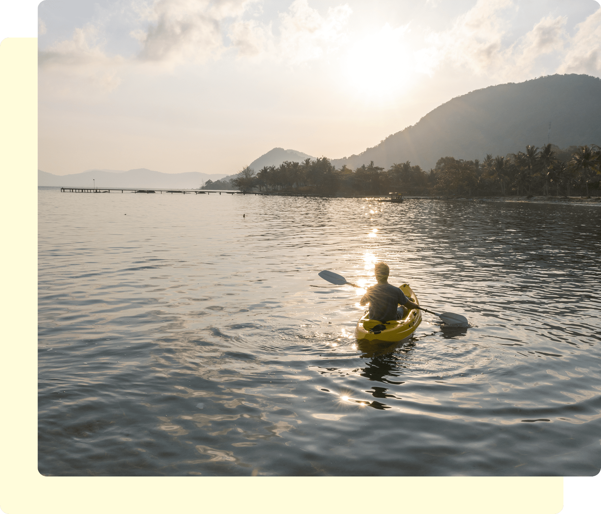 Person kayaking on a calm lake at sunset.