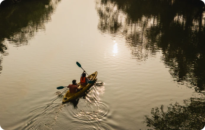 Two people kayaking on a calm river.