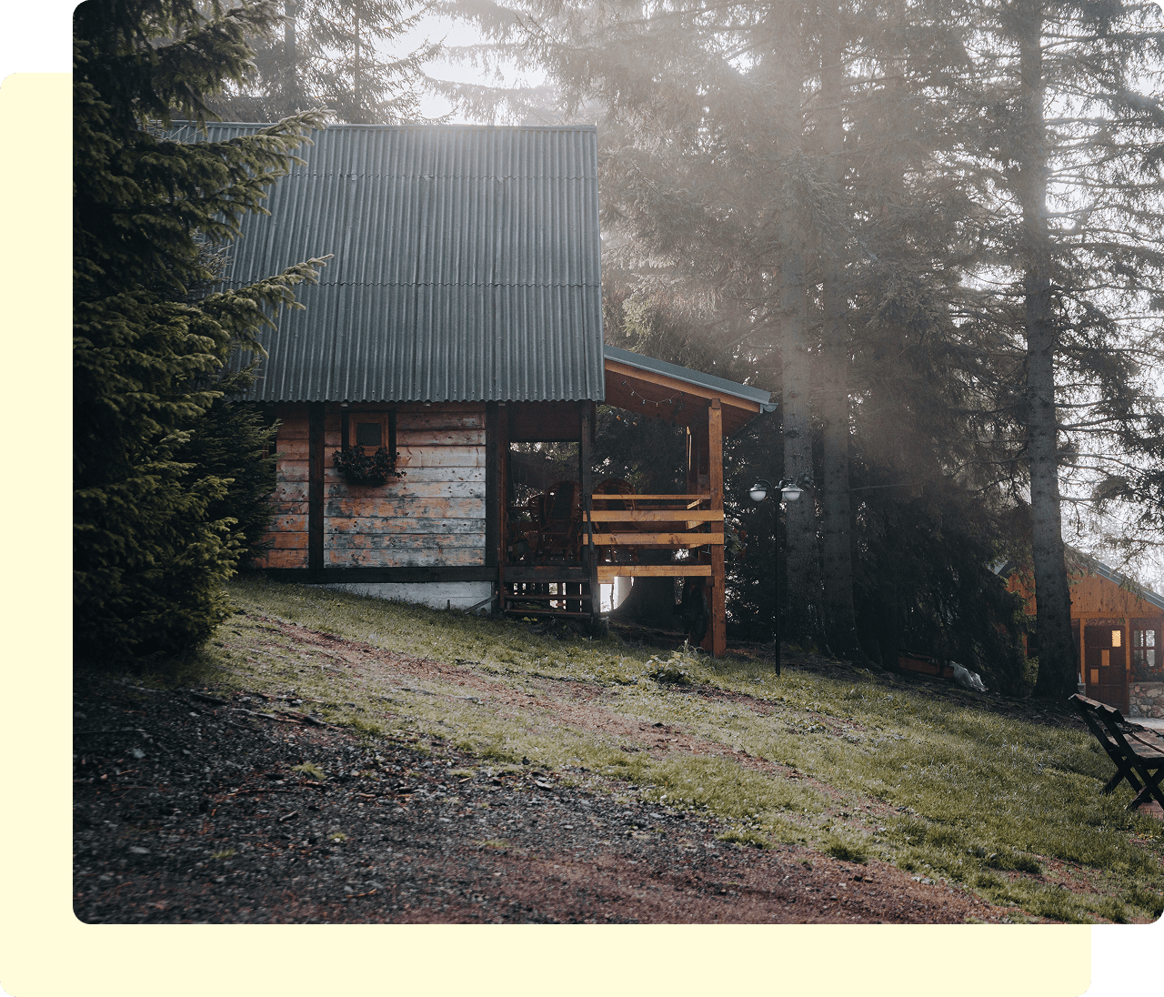 Wooden cabin surrounded by misty pine trees.