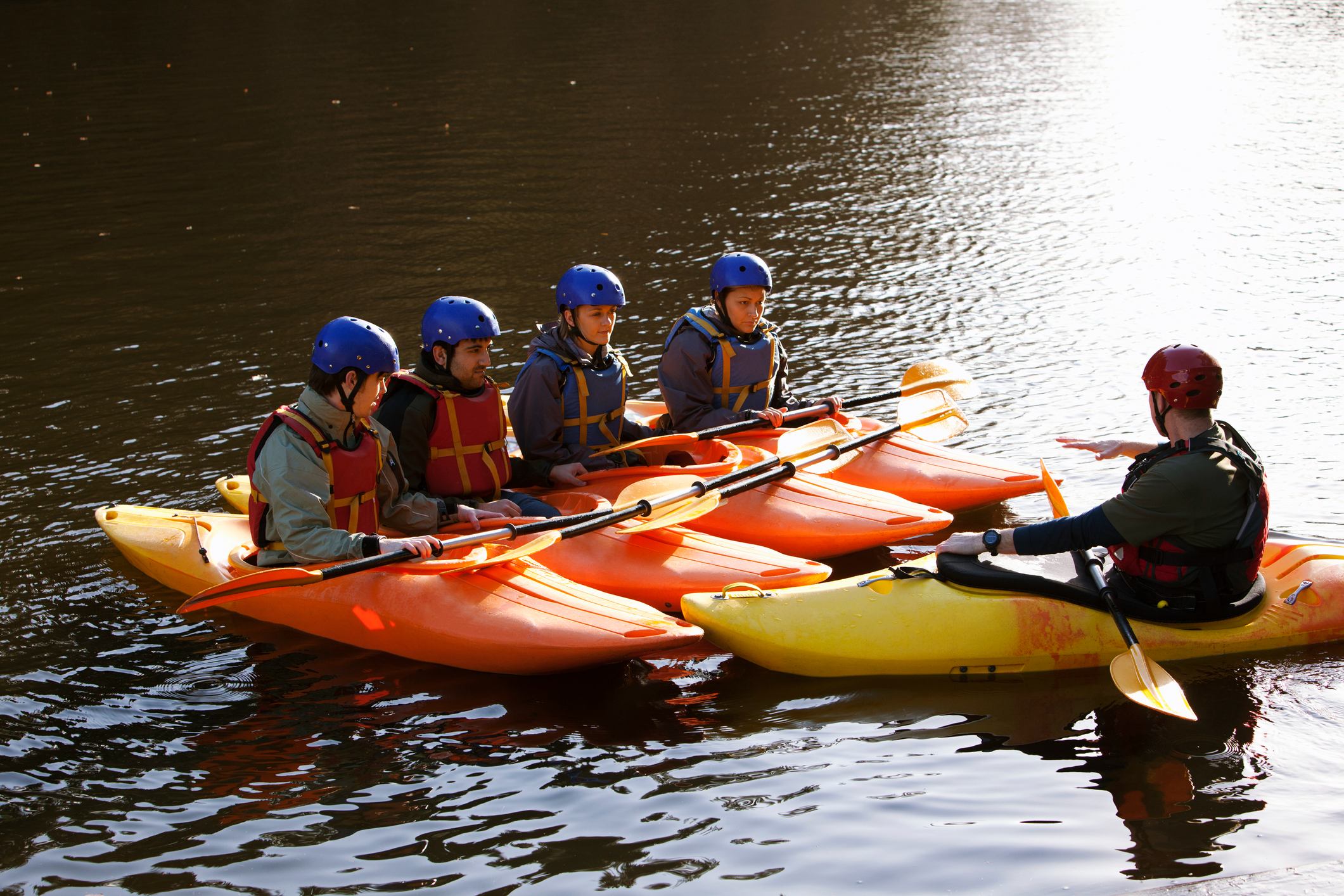 Group kayaking lesson on calm water