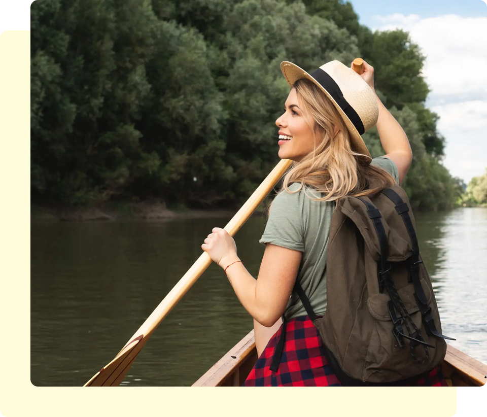 Woman paddling a canoe on a river.
