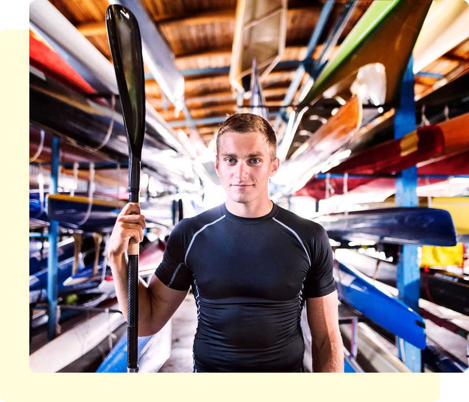 Man holding paddle in storage area.