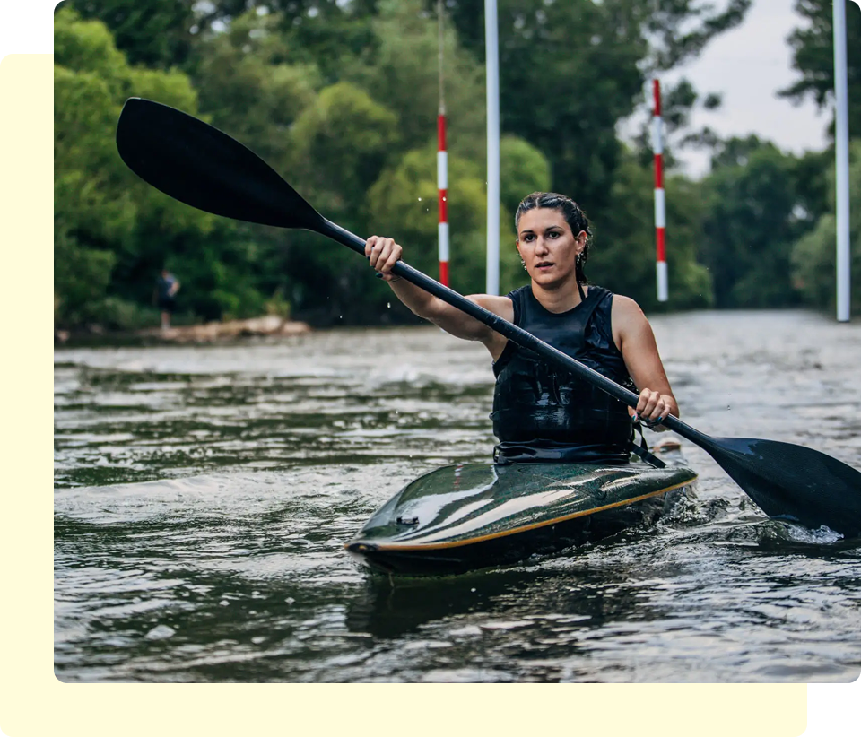 Person kayaking on a river course.