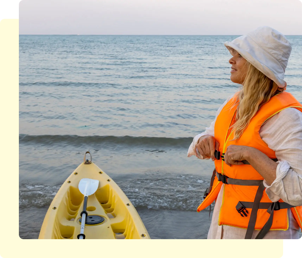 Woman with kayak on the beach, sunset.