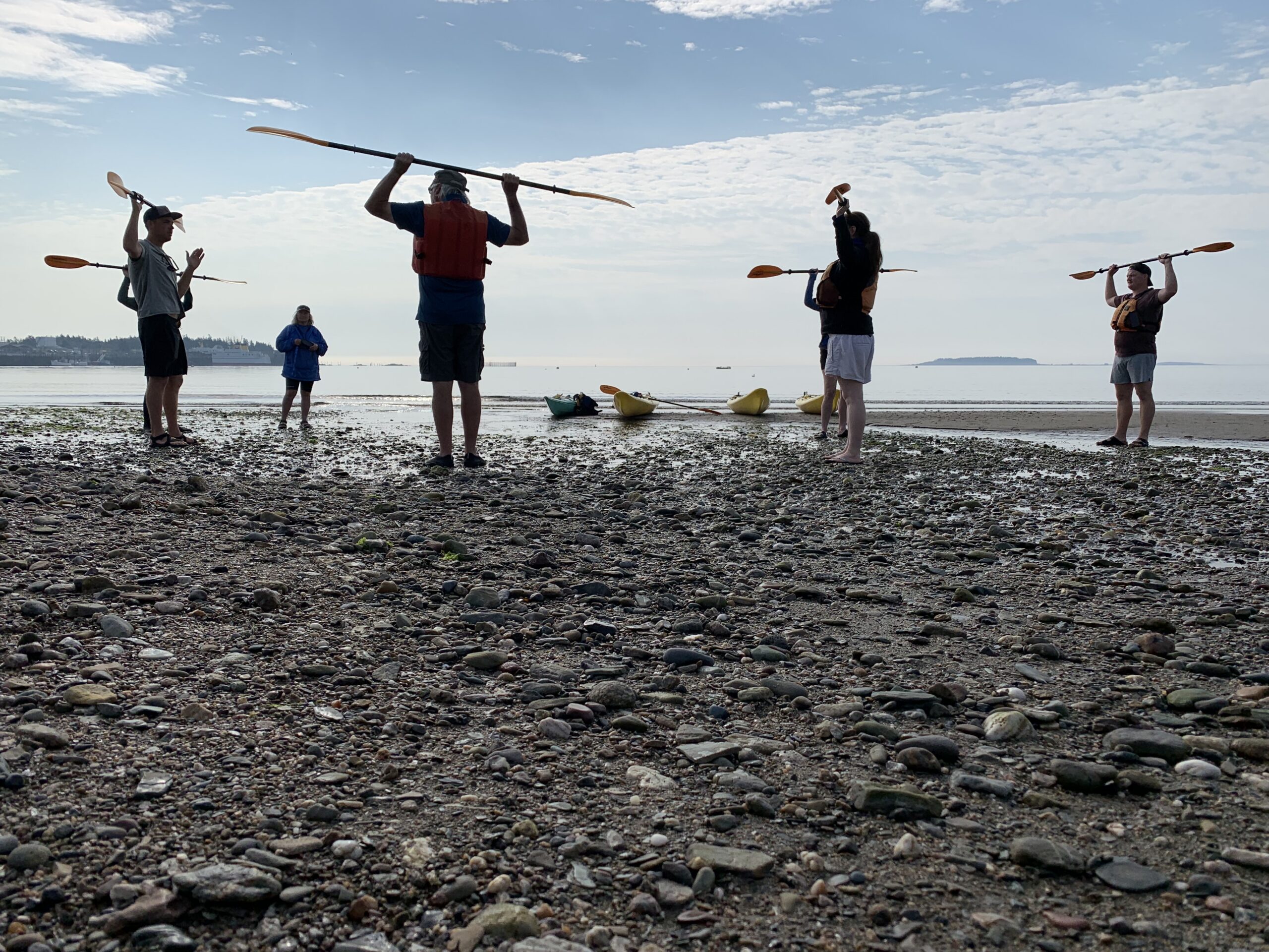 Kayakers warming up on the shoreline