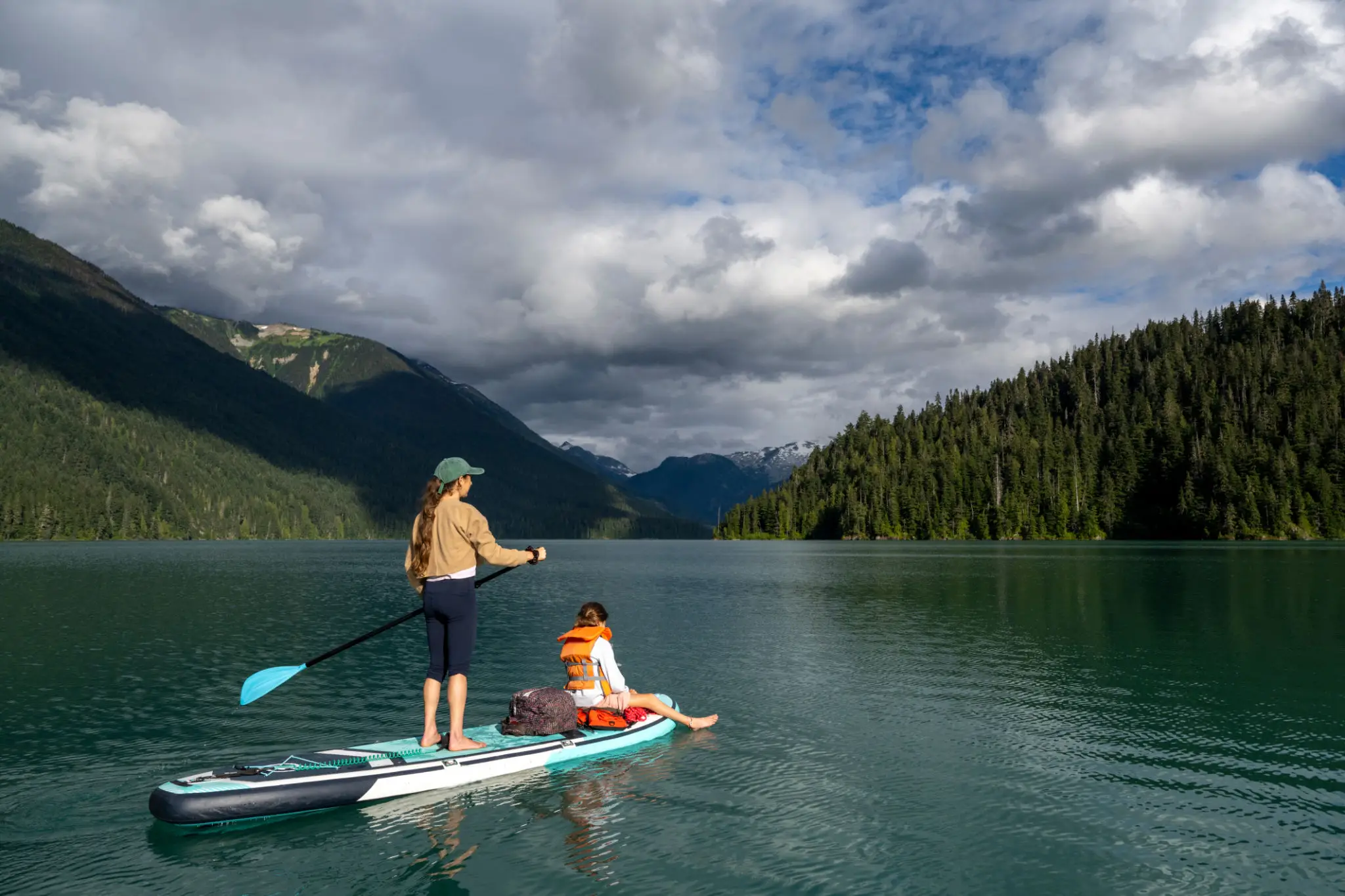 Paddleboarding on serene lake with mountains.