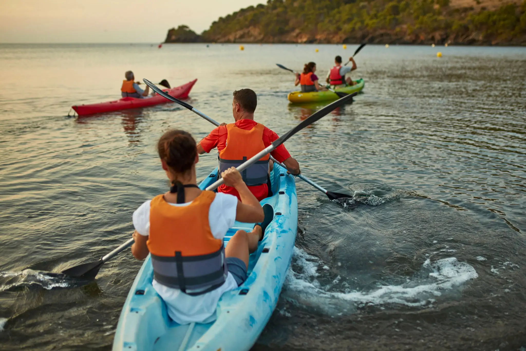 People kayaking on a calm sea.
