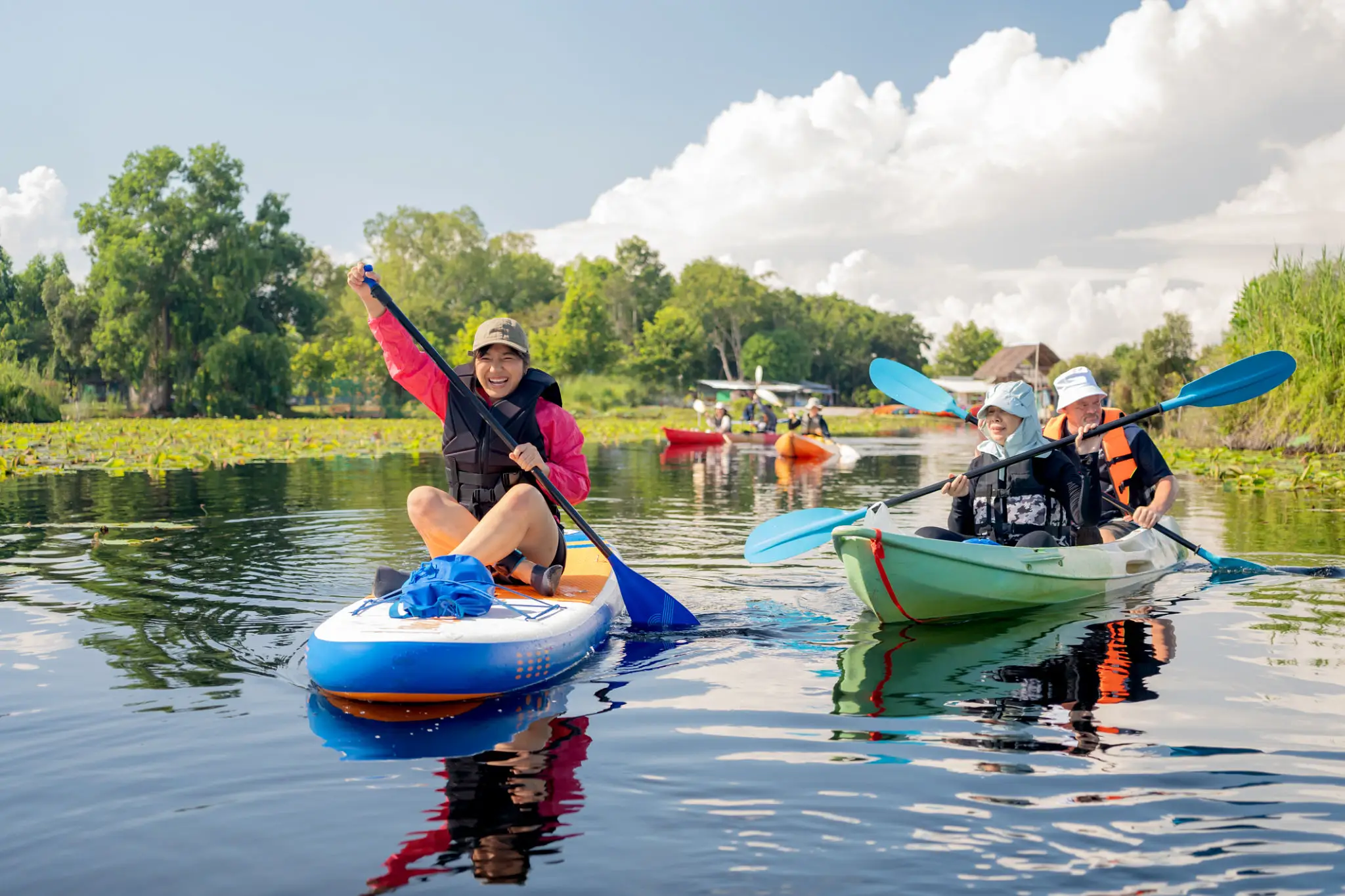 People kayaking and paddleboarding on a river.