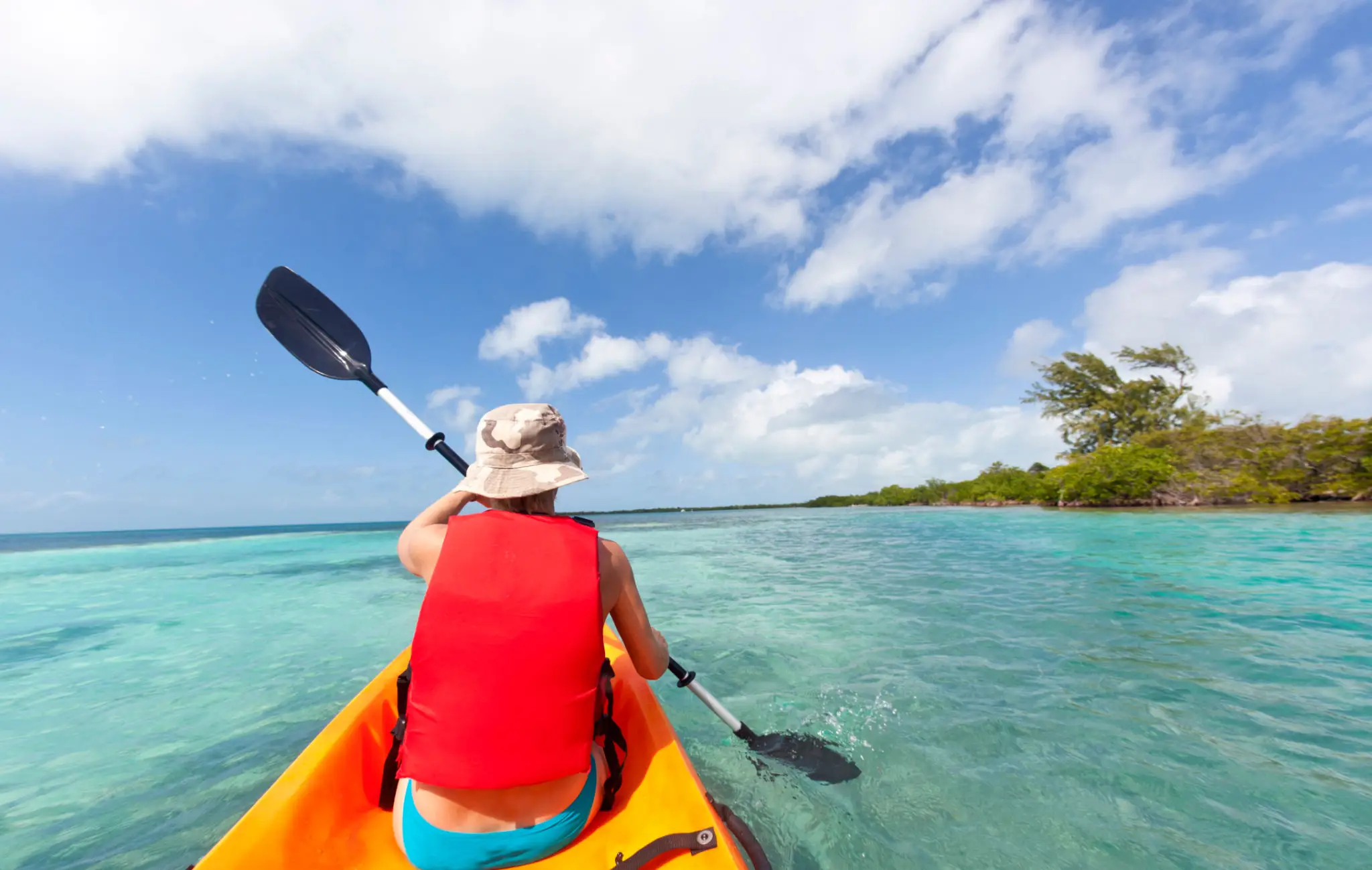 Kayaking on clear turquoise tropical waters.