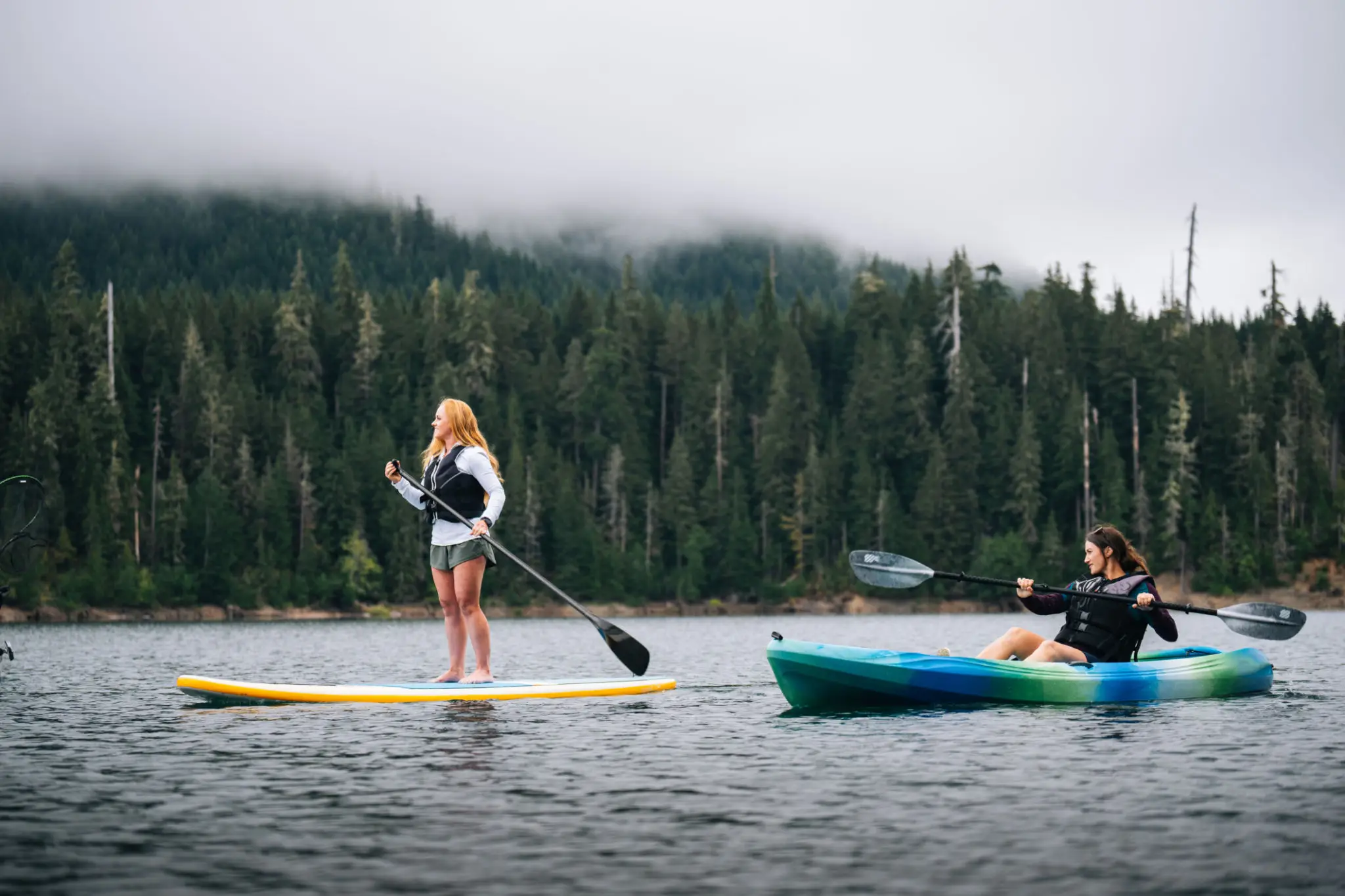 Paddleboarding and kayaking on a serene lake.