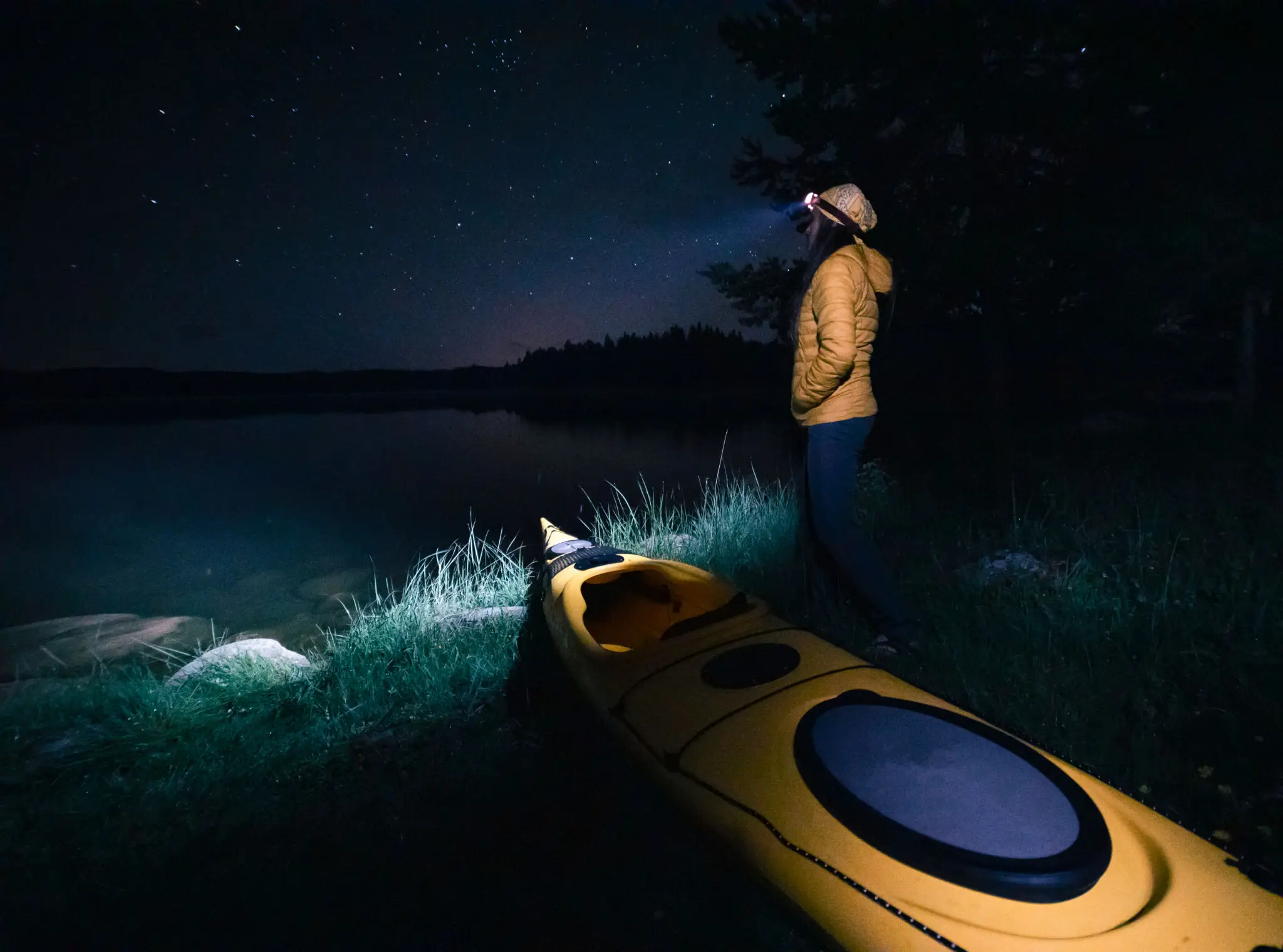 Person stargazing by kayak at night.