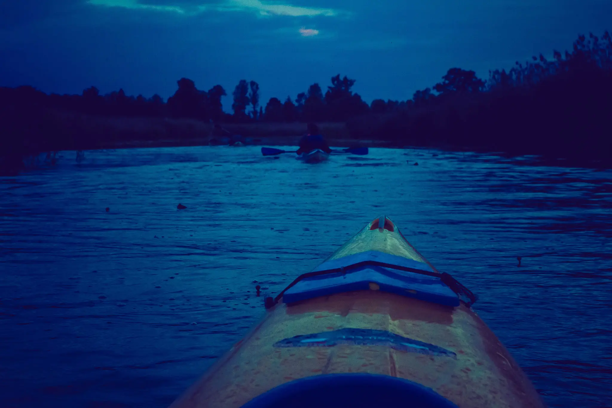 Kayaking on a river at dusk.