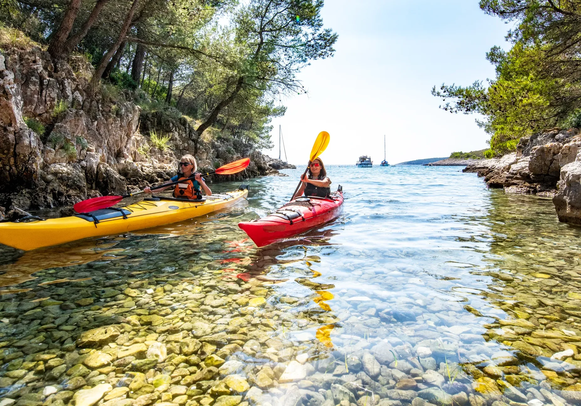Two kayaks exploring a scenic cove